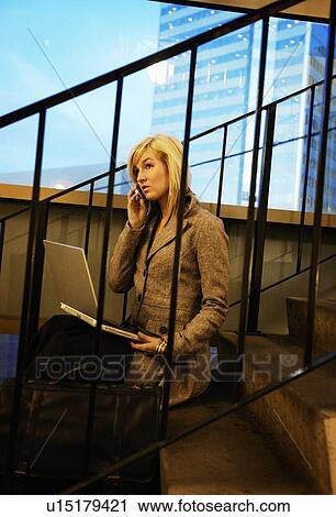 Stock Image - Woman on cell phone and lap top computer. Fotosearch