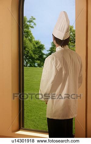 Stock Photo - A chef looking outside a window. Fotosearch