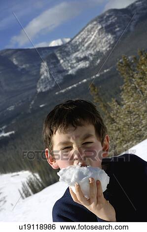 Stock Photograph - Boy eating snow. Fotosearch