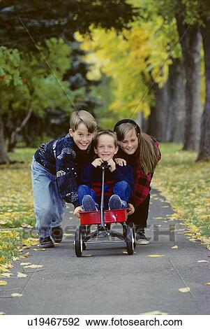 Stock Image - Children playing with wagon. Fotosearch