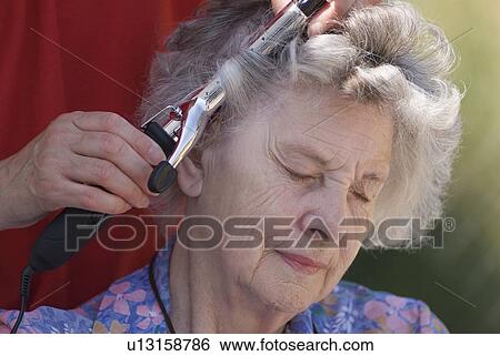 Stock Photograph - Elderly woman having hair curled. Fotosearch