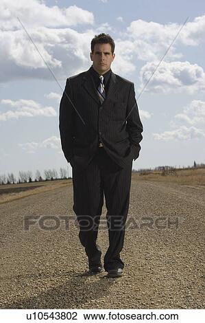 Stock Image - Man walking on road. Fotosearch