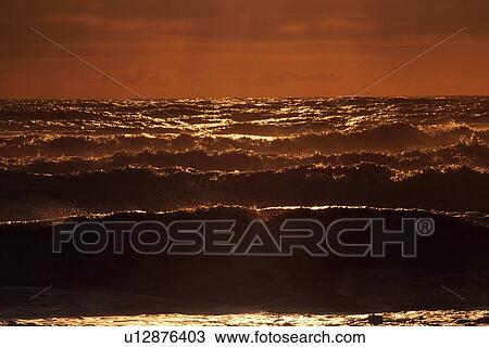 Stock Image - Ocean waves at sunset. Fotosearch