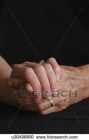 Stock Image - Senior couple holding hands. Fotosearch