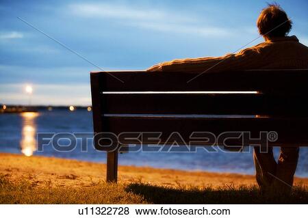 Stock Photo - Single man watching sunset. Fotosearch