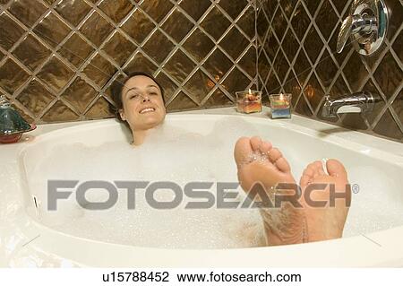 Stock Image - Woman having a bubble bath. Fotosearch