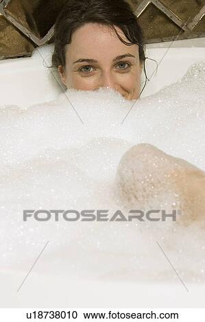 Stock Image - Woman having a bubble bath. Fotosearch