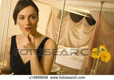 Woman putting on lipstick View Large Photo Image Stock Photo - Woman putting on lipstick. Fotosearch