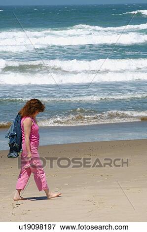Stock Photo - Woman walking on beach. Fotosearch