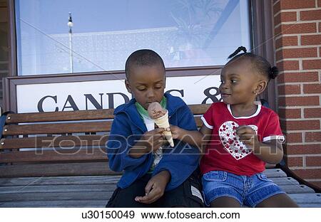 Stock Photo - Boy and girl sharing ice cream cone. Fotosearch