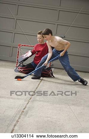 Boys playing hockey on driveway View Large Photo Image Picture - Boys playing hockey on driveway. Fotosearch
