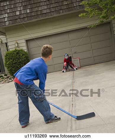 Boys playing hockey on driveway View Large Photo Image Stock Photo - Boys playing hockey on driveway. Fotosearch
