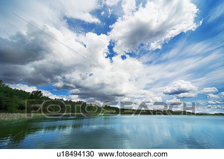 Stock Image - Cloud formation over body of water. Fotosearch