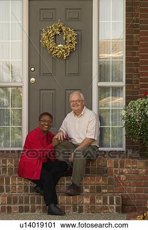 Stock Image - Couple sitting on the steps. Fotosearch