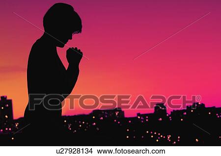 Picture - Female silhouette in prayer. Fotosearch