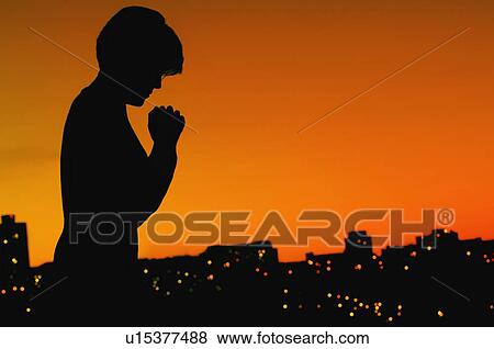 Stock Photo - Female silhouette in prayer. Fotosearch