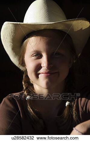 Stock Image - Girl in cowboy hat smiling. Fotosearch