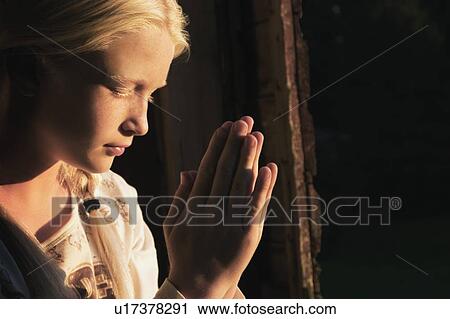 Girl praying in the dark View Large Photo Image Stock Image - Girl praying in the dark. Fotosearch