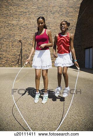 Girls jumping rope together View Large Photo Image Stock Image - Girls jumping rope together. Fotosearch