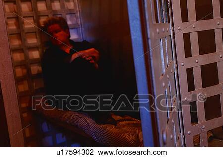 Stock Image - Man in jail cell. Fotosearch