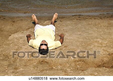 Man laying on beach View Large Photo Image Stock Photo - Man laying on beach. Fotosearch