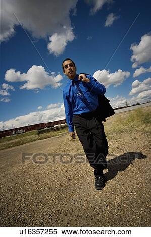Stock Photography - Man walking near railroad tracks. Fotosearch