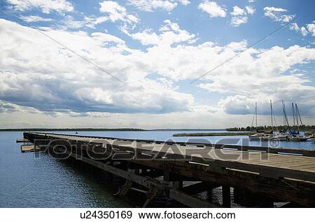 Pier overlooking sailboats and lake View Large Photo Image Stock Photo - Pier overlooking sailboats and lake. Fotosearch