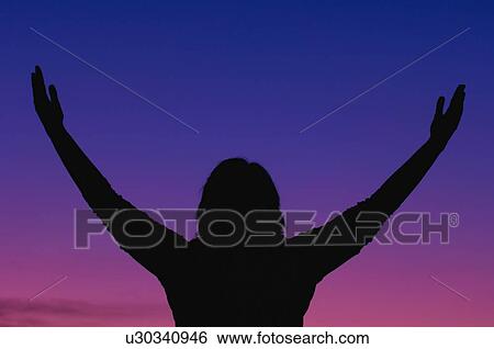 Silhouette of a woman worshipping in nature View Large Photo Image Stock Photograph - Silhouette of a woman worshipping in nature. Fotosearch