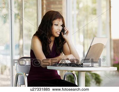 Woman talking on cell phone with laptop View Large Photo Image Stock Photography - Woman talking on cell phone with laptop. Fotosearch