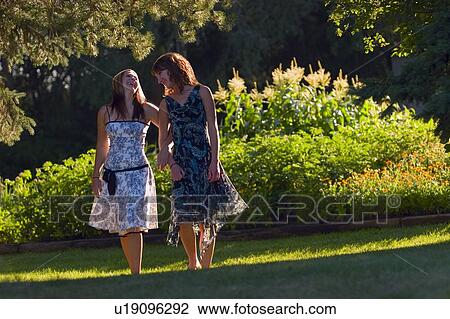 Young women strolling through the park View Large Photo Image Stock Image - Young women strolling through the park. Fotosearch