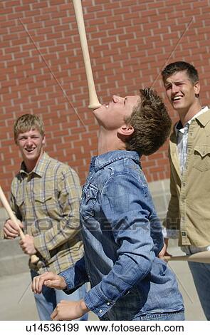 Stock Photo - Youth balancing bats. Fotosearch