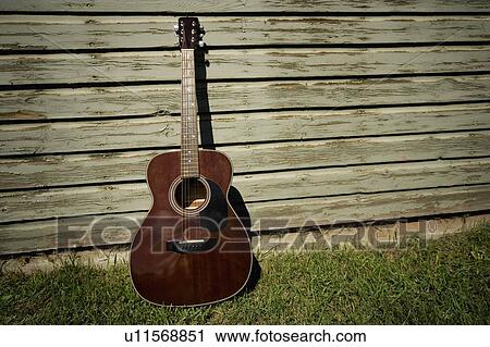 Acoustic guitar leaning against building View Large Photo Image Stock Image - Acoustic guitar leaning against building. Fotosearch