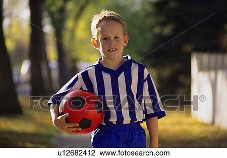 Boy carrying soccer ball View Large Photo Image Stock Image - Boy carrying soccer ball. Fotosearch