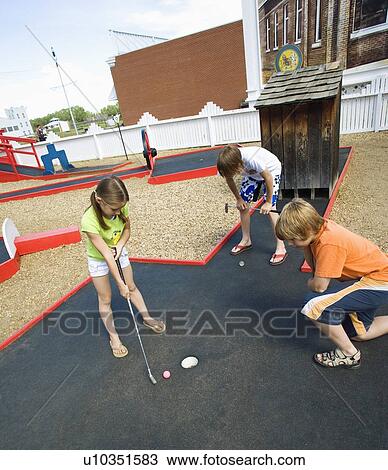 Stock Image - Children playing mini golf. Fotosearch