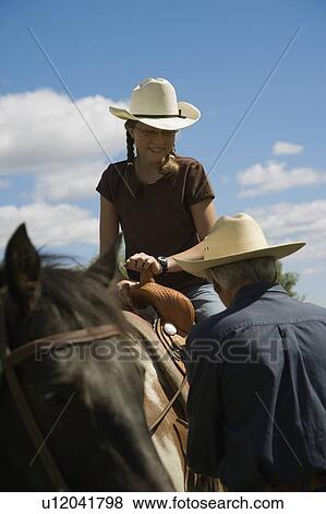 Stock Photo - Girl on horseback with grandfather. Fotosearch