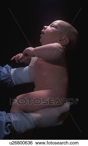Stock Photograph - Health professional holding newborn baby. Fotosearch
