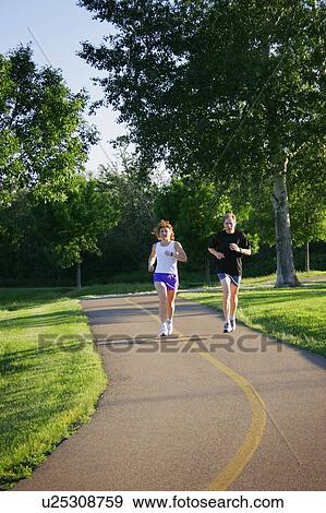 Man and woman jogging on trail View Large Photo Image Stock Photo - Man and woman jogging on trail. Fotosearch