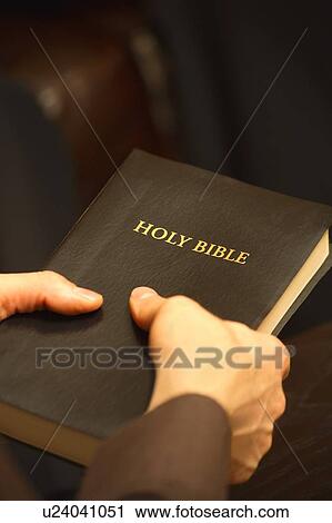 Stock Image - Man holding Bible. Fotosearch