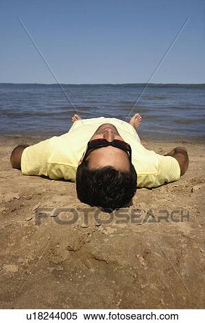 Man lying on beach View Large Photo Image Stock Photography - Man lying on beach. Fotosearch