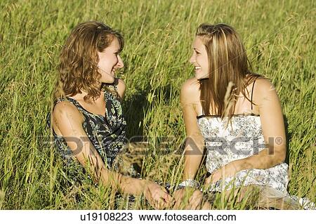Two women sitting in field talking View Large Photo Image Stock Image - Two women sitting in field talking. Fotosearch