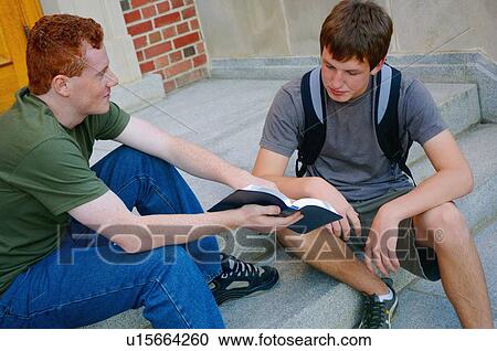 Two young men sitting on steps discussing the Bible View Large Photo Image Stock Image - Two young men sitting on steps discussing the Bible. Fotosearch