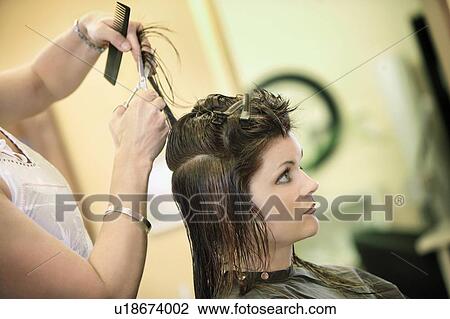 Stock Image - Woman having her hair cut. Fotosearch