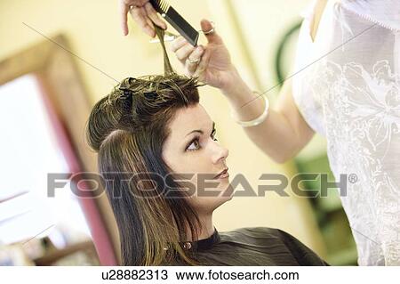 Stock Image - Woman having her hair cut. Fotosearch