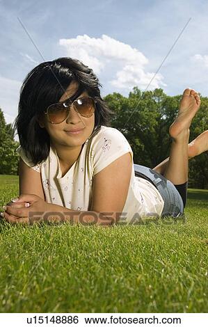 Woman laying on the grass View Large Photo Image Stock Photograph - Woman laying on the grass. Fotosearch