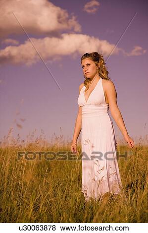 Woman standing in a field View Large Photo Image Stock Photo - Woman standing in a field. Fotosearch