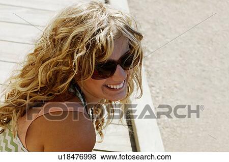 Woman wearing sunglasses smiling View Large Photo Image Stock Photo - Woman wearing sunglasses smiling. Fotosearch