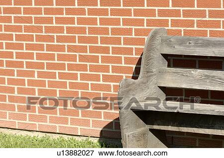 Wooden bench against brick wall View Large Photo Image Stock Photo - Wooden bench against brick wall. Fotosearch