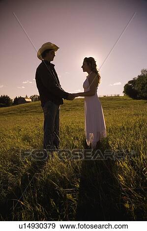 Young man and woman in field holding hands View Large Photo Image Stock Photo - Young man and woman in field holding hands. Fotosearch