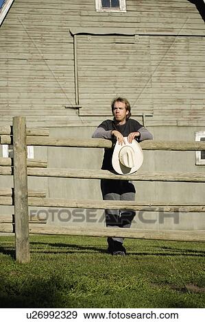 Stock Photo - Young man leaning on fence. Fotosearch