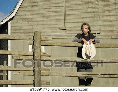 Young man leaning on fence View Large Photo Image Stock Photography - Young man leaning on fence. Fotosearch